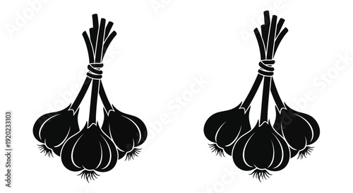 Two bundles of garlic hanging depicted in a stark silhouette
