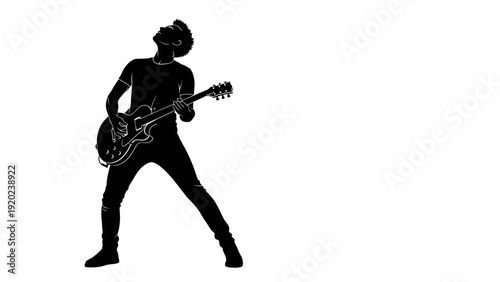 Silhouette of a man playing an electric guitar with passion.