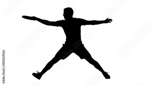 Silhouette of a man playing frisbee in mid-air.