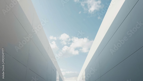 Minimal modern architectural corridor with open sky and soft clouds, serene light