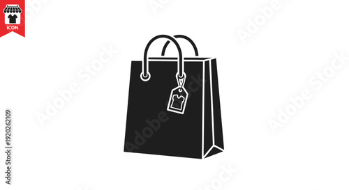 A simple black shopping bag with a tag on it standing alone on a plain white background from a straightforward viewpoint