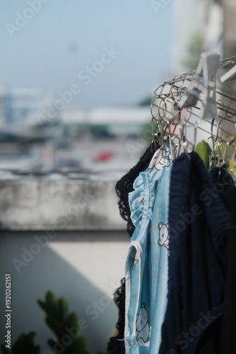 Clothes hanging on outdoor clothesline with sunlight and soft shadow, lifestyle concept
