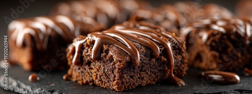 Obraz  z motywem Decadent Brownie Squares Topped with Rich Chocolate Drizzle on a Slate Background