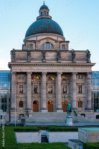 Modern colonnade with stacked stones in foreground and glass roof perspective