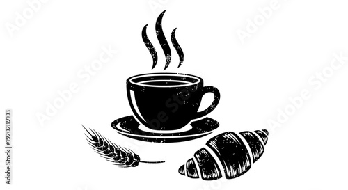 A steaming cup of coffee on a saucer with a croissant and wheat ear on a tabletop viewed from directly above