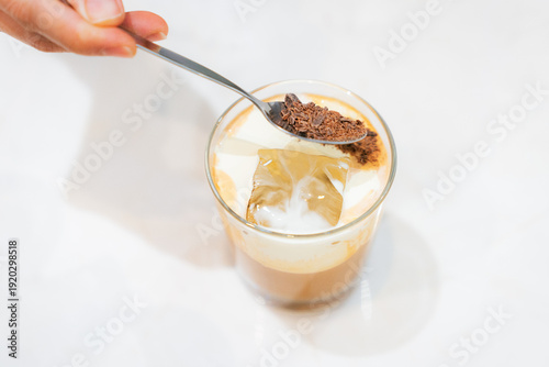 Wallpaper Mural Sprinkling chocolate shavings on iced latte with ice cubes Torontodigital.ca