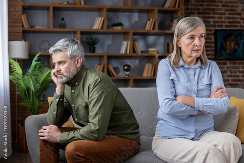 Fotografija Dissatisfied senior man and woman sitting apart on a sofa at home, feeling upset