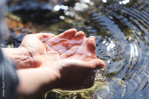 The clear, clean water of a pristine stream, the precious water of life held in your hands, World Water Day background
