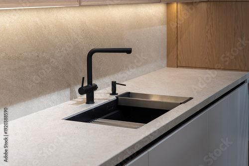 Matte black kitchen sink and faucet on gray stone countertop