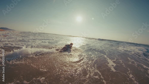 Hippie surfer. Young man in colorful stylish shirt walks on the beach and enters the ocean. Brazilian hippie surfer