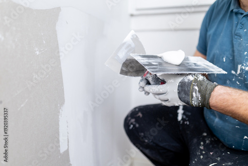Fotografie Worker applying finishing touches to drywall in a home renovation project during