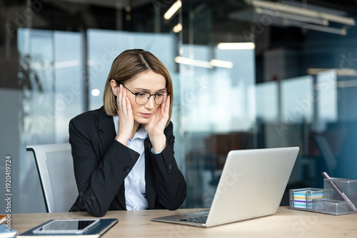 Slika na platnu Businesswoman placing hands on temples, feeling a headache and stress while look
