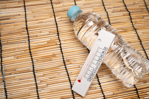 Summer Heatstroke Concept with Water Bottle and Thermometer