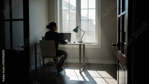 Solitary Man with Coffee at Desk in Sunlit Home Office Setting