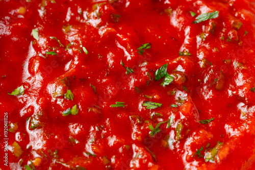 Tomato sauce with fragrant herbs background, ideal for culinary presentations, detailed view. Close up shot. Copy space. Top view.