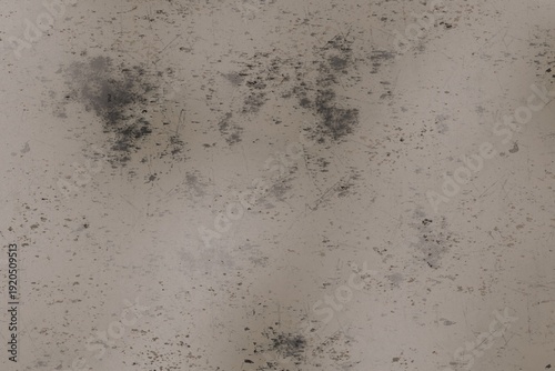 Distressed light beige surface with prominent dark gray splotches, numerous fine scratches, and scattered speckles, presenting an aged and weathered texture