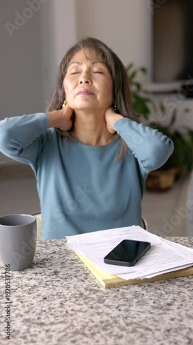 Business woman sitting at counter working from home suffering stress headache rubbing neck with discomfort pain vertical video