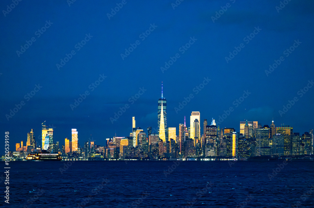 Obraz premium Manhattan skyline with One World Trade Center at night reflected in Hudson River New York City USA