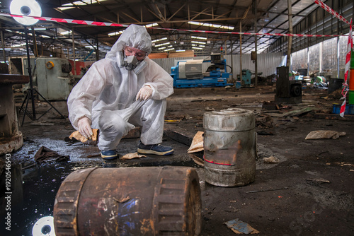 person in mask. Hazardous control related to factory chemicals. Employees are disposing of harmful substances. in a chemical protective suit in a factory	
