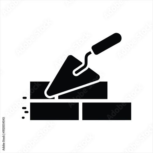 Bricklaying Essence: A stark black-and-white image showcases the essence of construction, with a trowel poised above expertly laid bricks, representing building and craftsmanship.