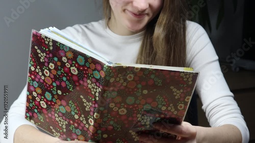 Young woman reading her personal notebook or book at home.