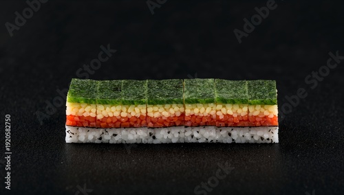 Sushi Roll Prepared With Vegetables and Rice Cut Into Small Pieces on a Black...