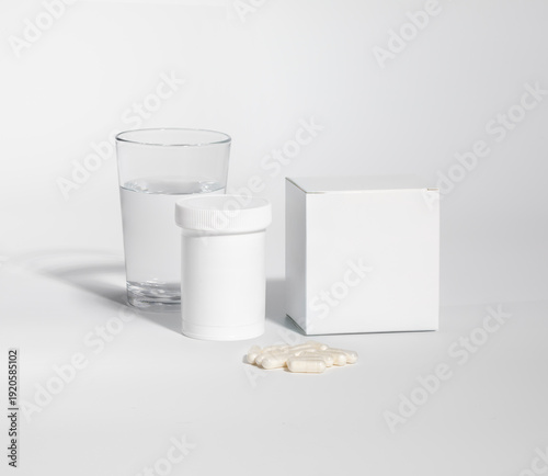 Mockup of a box, pill bottle of medicine, pills and glass of water