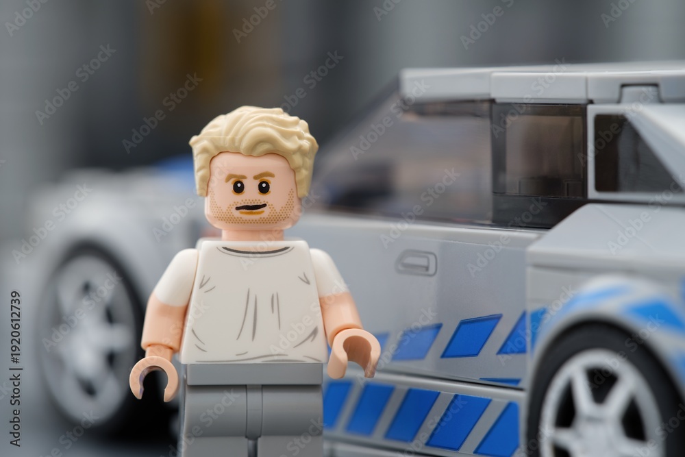 Obraz premium Tambov, Russian Federation - August 21, 2025 Portrait of a Lego Brian OConner minifigure near his Nissan Skyline GT-R (R34) car. 2 Fast 2 Furious movie. Lego Speed Champions