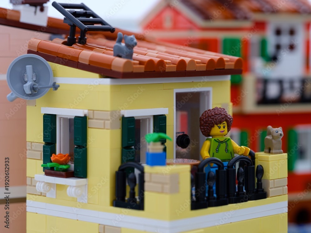 Fototapeta premium Tambov, Russian Federation - January 05, 2026 Lego woman minifigure standing on her balcony with cats. LEGO Ideas Italian Riviera set.