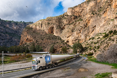 Oversized wind turbine blade transport by trucks on a winding road