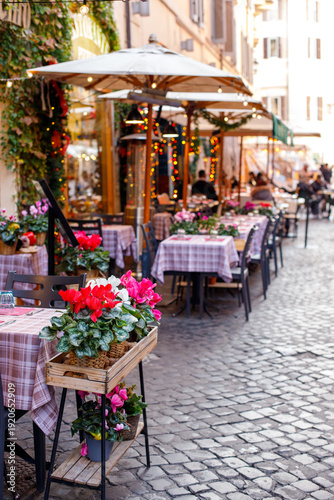 Photography Cozy outdoor restaurant terrace on a narrow cobblestone street in Europe