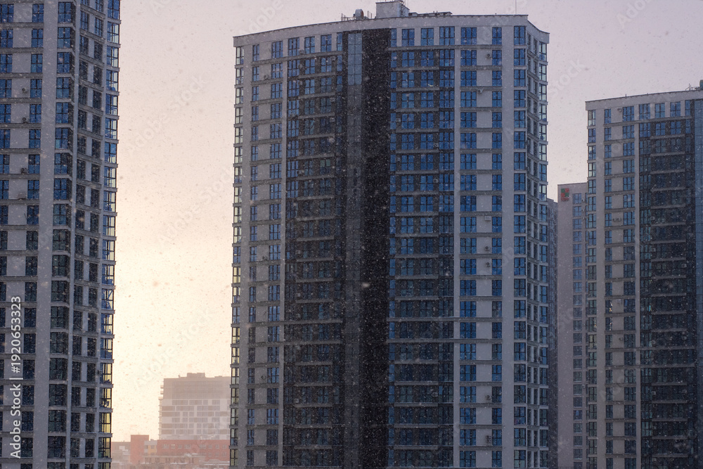 Obraz premium Dusk casts warm reflections on towering residential blocks in lively metropolitan area