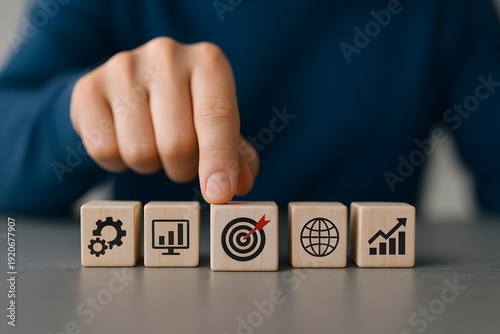 Hand points to a wooden block with a target icon, emphasizing business goals and focused achievement.