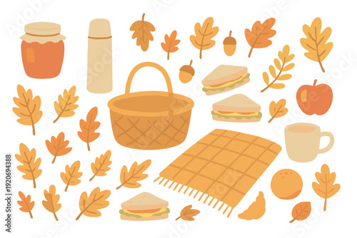 Basket with food items and autumn leaves displayed on a blanket in a nature setting during fall