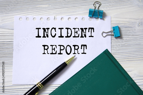 INCIDENT REPORT - words in white paper on the background of a diary, glasses and pen