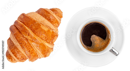 Overhead view of espresso in white cup and golden butter croissant isolated on light background, minimal breakfast bakery concept