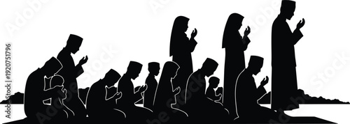 Muslim family praying together during sunset in silhouette