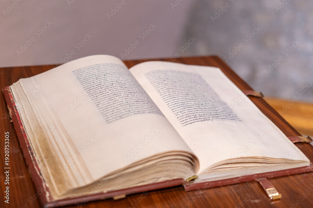 Fototapeta premium Open antique book on wooden table with soft focus