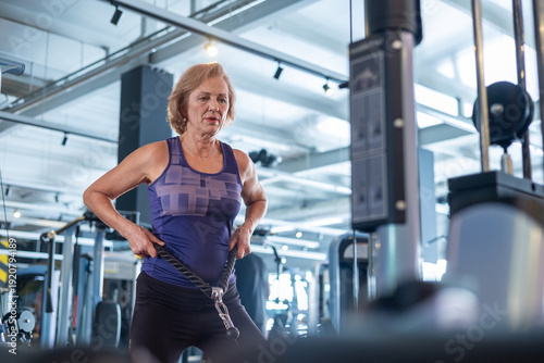 Photos Senior woman doing cable rope exercise in gym, strength training and muscle building for elderly women over 60