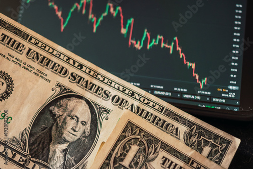 Photos American dollar bills next to a downward-sloping chart of a stock broker