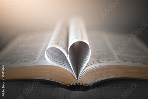 Obraz na plátně open bible with pages folded into heart shape, christian love and faith concept