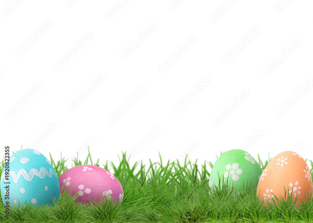 Fototapeta premium Easter eggs in green grass against white background