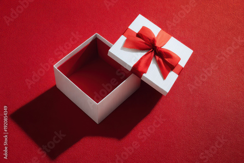 Open White Gift Box with Red Ribbon on Red Background