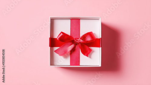 White Gift Box with Red Ribbon on Pink Background