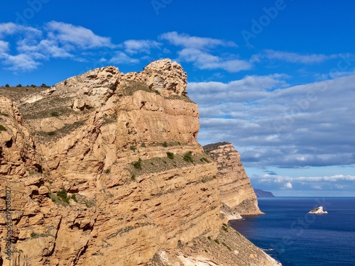 Foto Sunny coastal cliffs with ferry and waves, Majestic sandstone cliffs overlooking