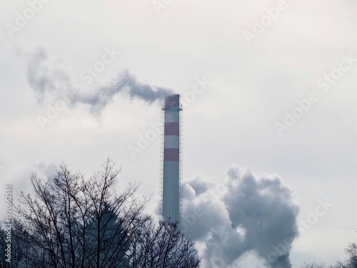 Pollution affecting surroundings. Hazy sky over trees and factories impacts community health safety