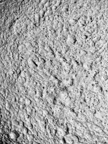 Monochrome close-up of fermented yeast dough surface with detailed air pockets and organic structure. High contrast black and white food texture background highlighting natural baking patterns.