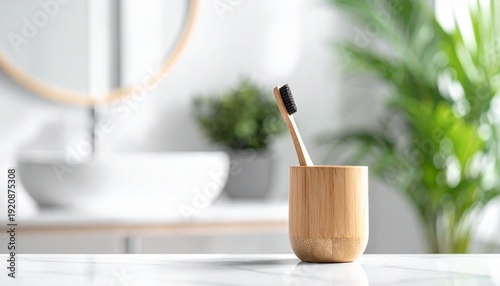 Eco-friendly bamboo toothbrush with black bristles in a wooden cup on a modern marble bathroom counter.