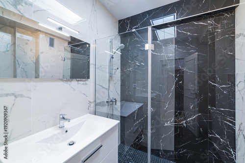 Modern bathroom interior with glass shower and marble tiles