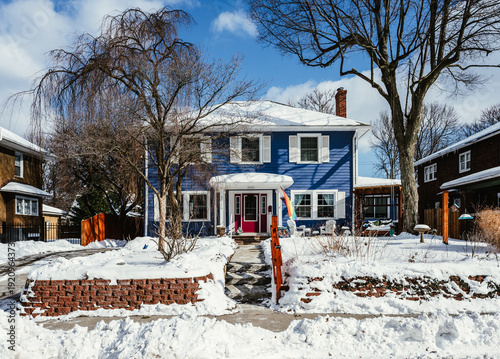 A blue house in snow on a sunny day after a winter storm